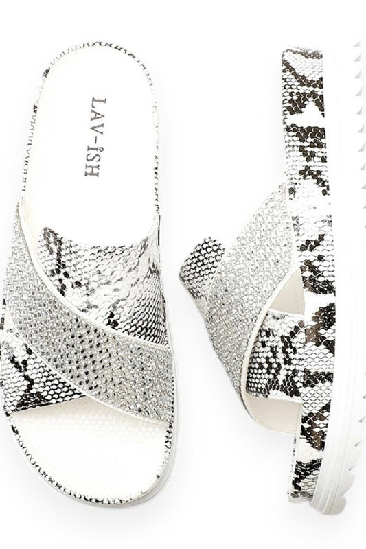 A pair of women's slide sandals with a silver and black snakeskin pattern, featuring a white insole with the brand name 'LAV-ISH' printed on it, set against a plain white background.