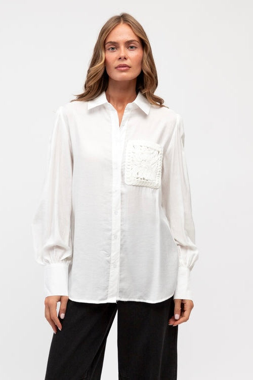 Woman wearing a white shirt with a pocket on a white background