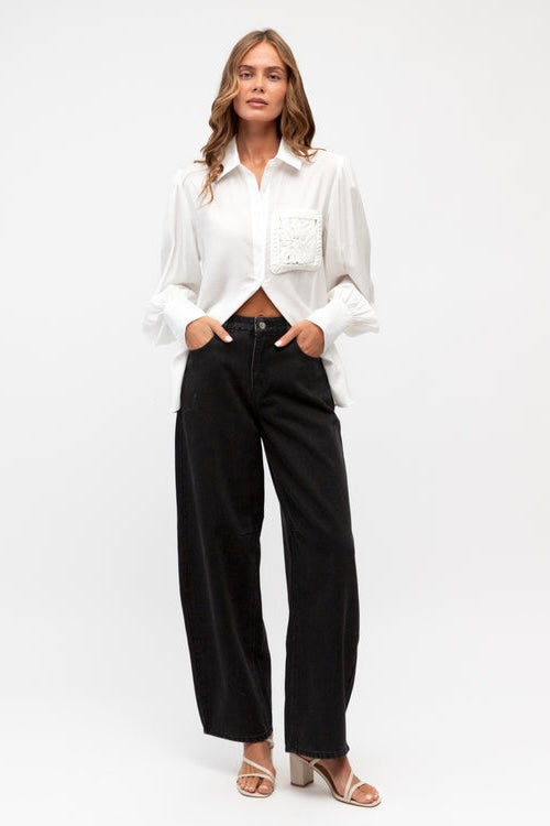 Woman wearing a white blouse and black pants on a white background