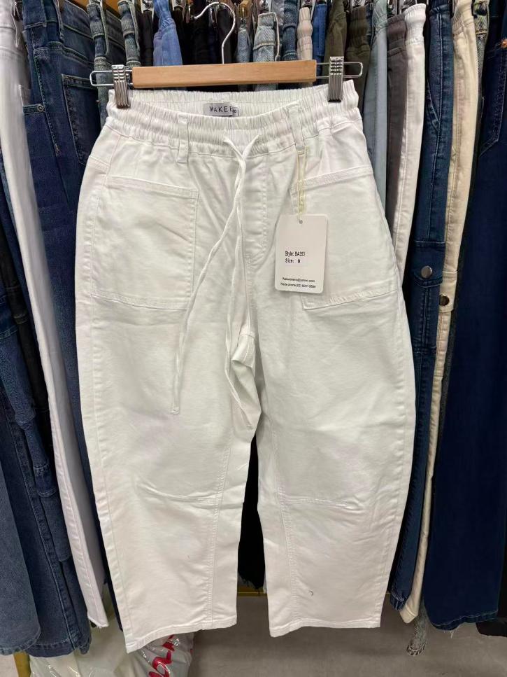 White pants with a tag on a rack of clothes