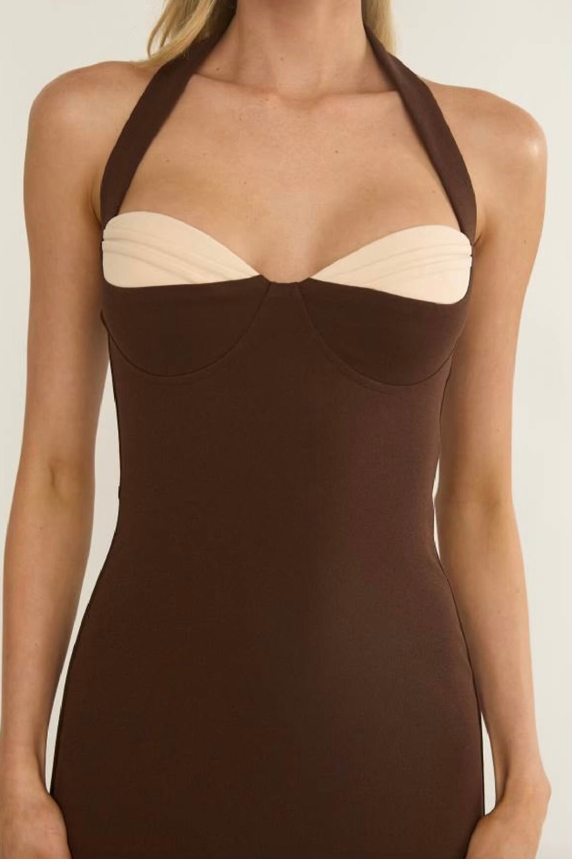 Brown halter neck dress with beige accents on a plain background