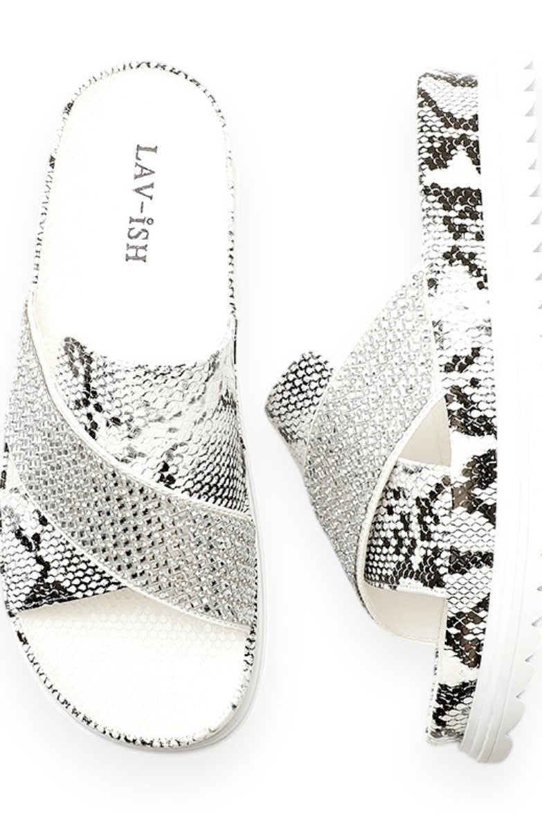 A pair of women's slide sandals with a silver and black snakeskin pattern, featuring a white insole with the brand name 'LAV-ISH' printed on it, set against a plain white background.