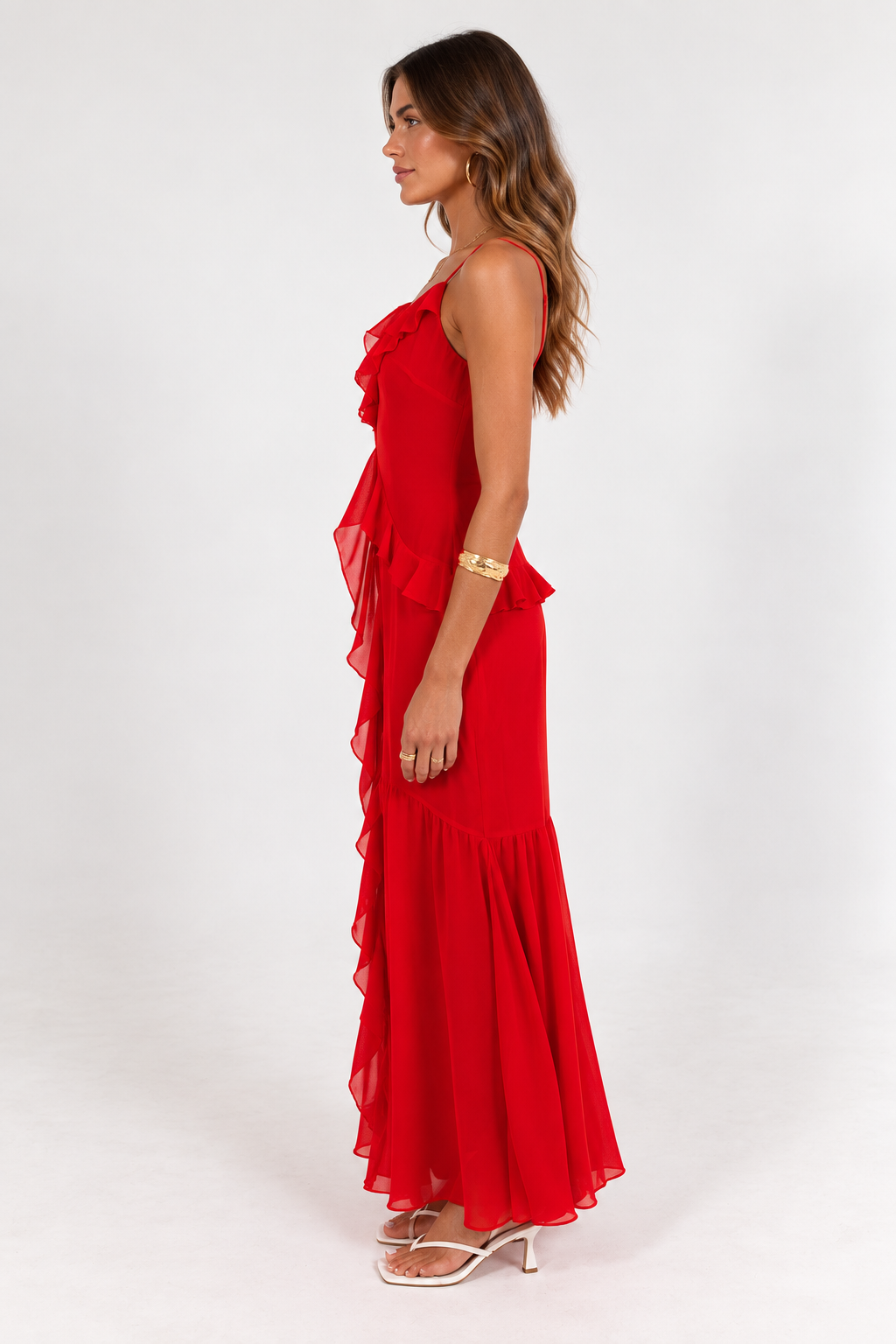 Side view of the red Perry Maxi Dress showing the front frills and long, flowing silhouette
