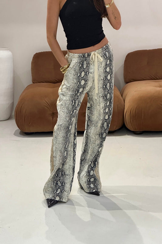 Person wearing snake print racer pants and a black top