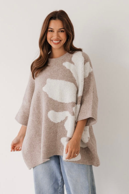 Woman wearing a beige and white flower patterned jumper