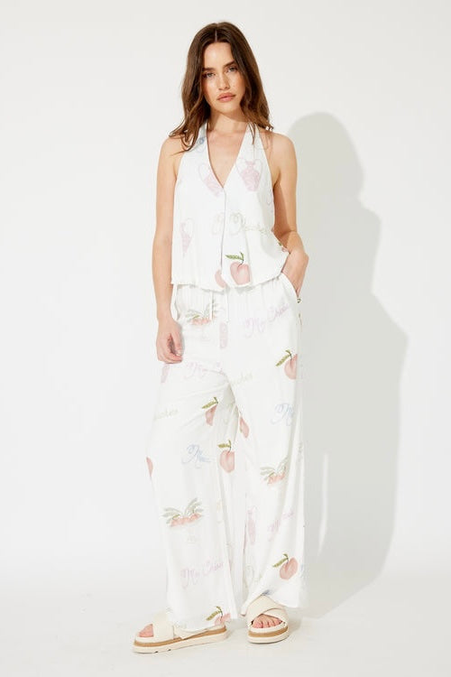 Woman wearing a white peaches pant set with halter vest