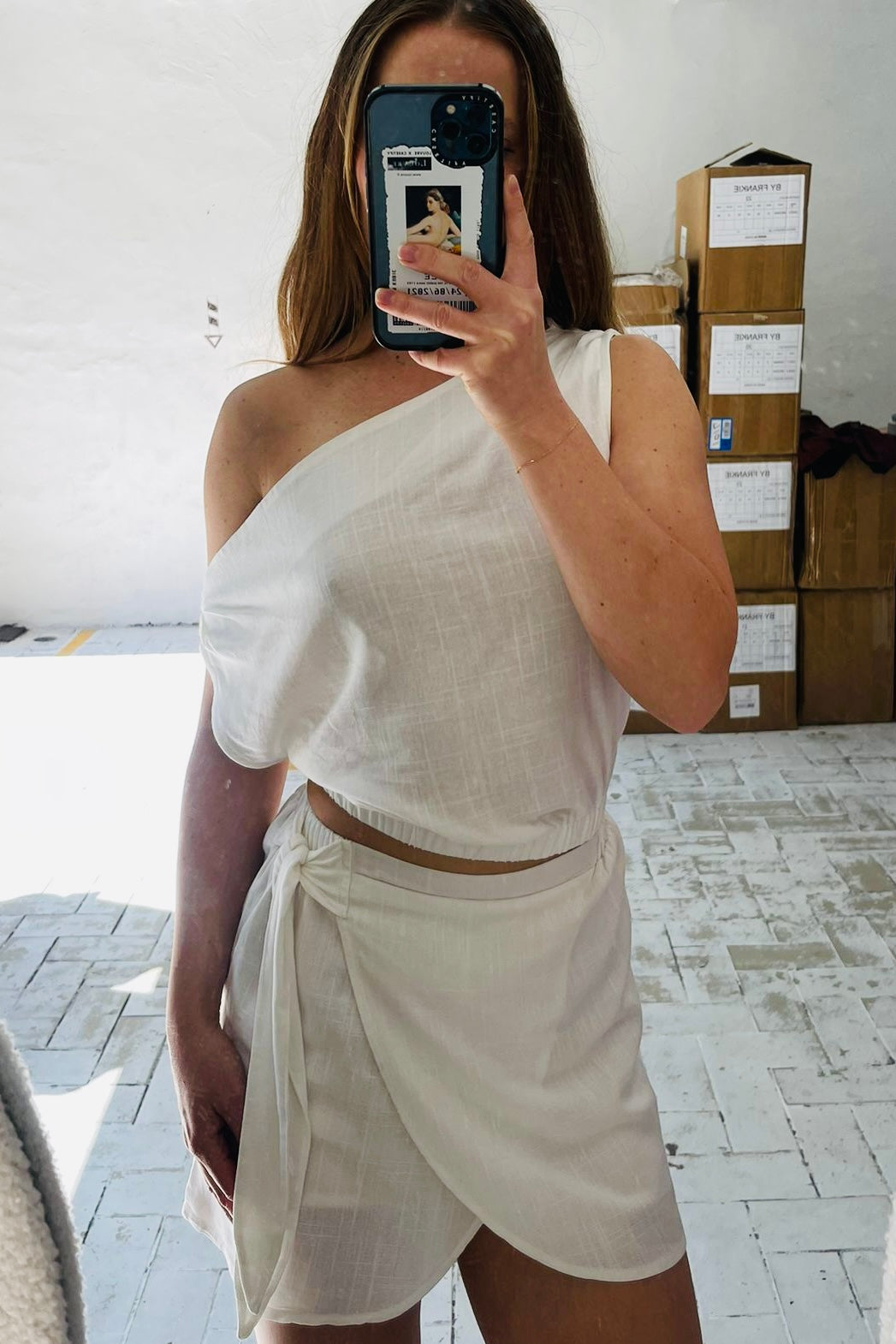 Person wearing a white off-shoulder top and skort