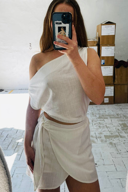 Person wearing a white off-shoulder top and skort
