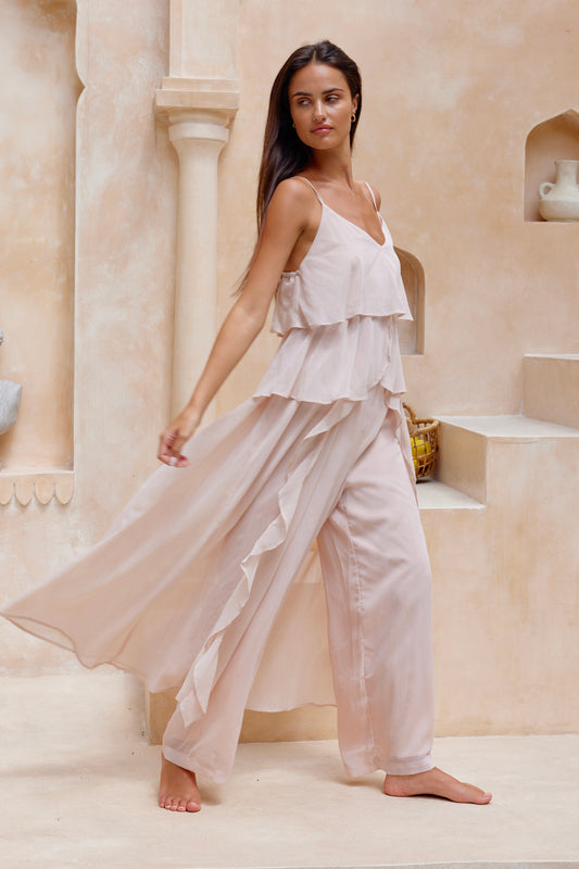 Woman wearing a light pink pant set by jatea the label chiffon drapey Allegra set